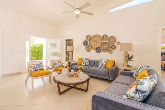 Heller Wohnraum mit Sofas, Dekorationswänden und farbenfrohen Kissen.