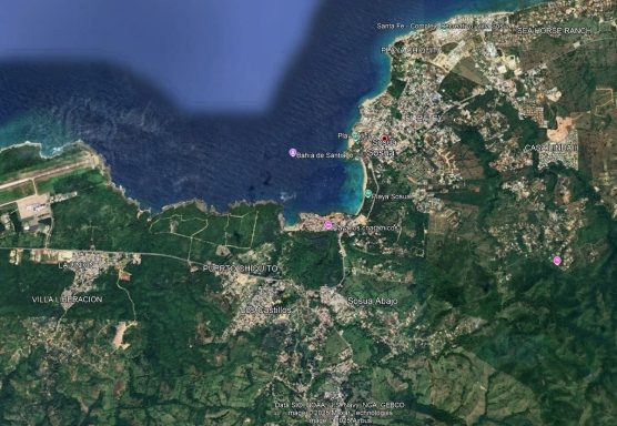 Luftaufnahme einer Küstenregion mit Wasser, Bergen und Siedlungen.