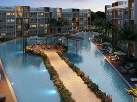 Moderne Wohnanlage in Punta Cana mit Schwimmbad, Garten und Sitzbereichen in der Abenddämmerung.